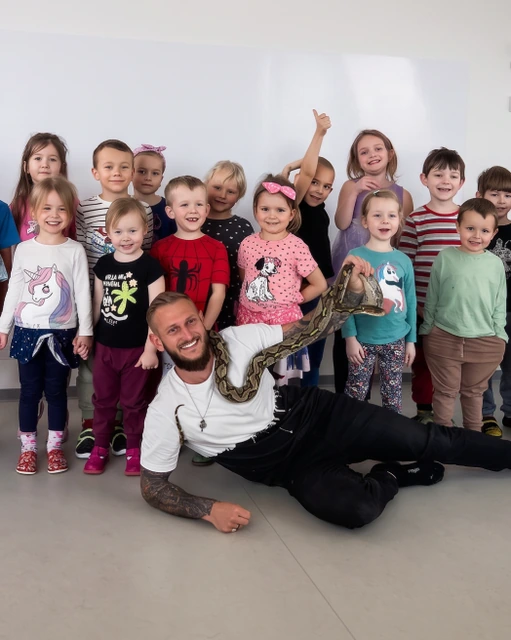 Děti kolem Zdeňka s krajtou na zahradě